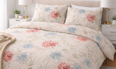 Person wrapped in a blanket in the snow with a laptop.